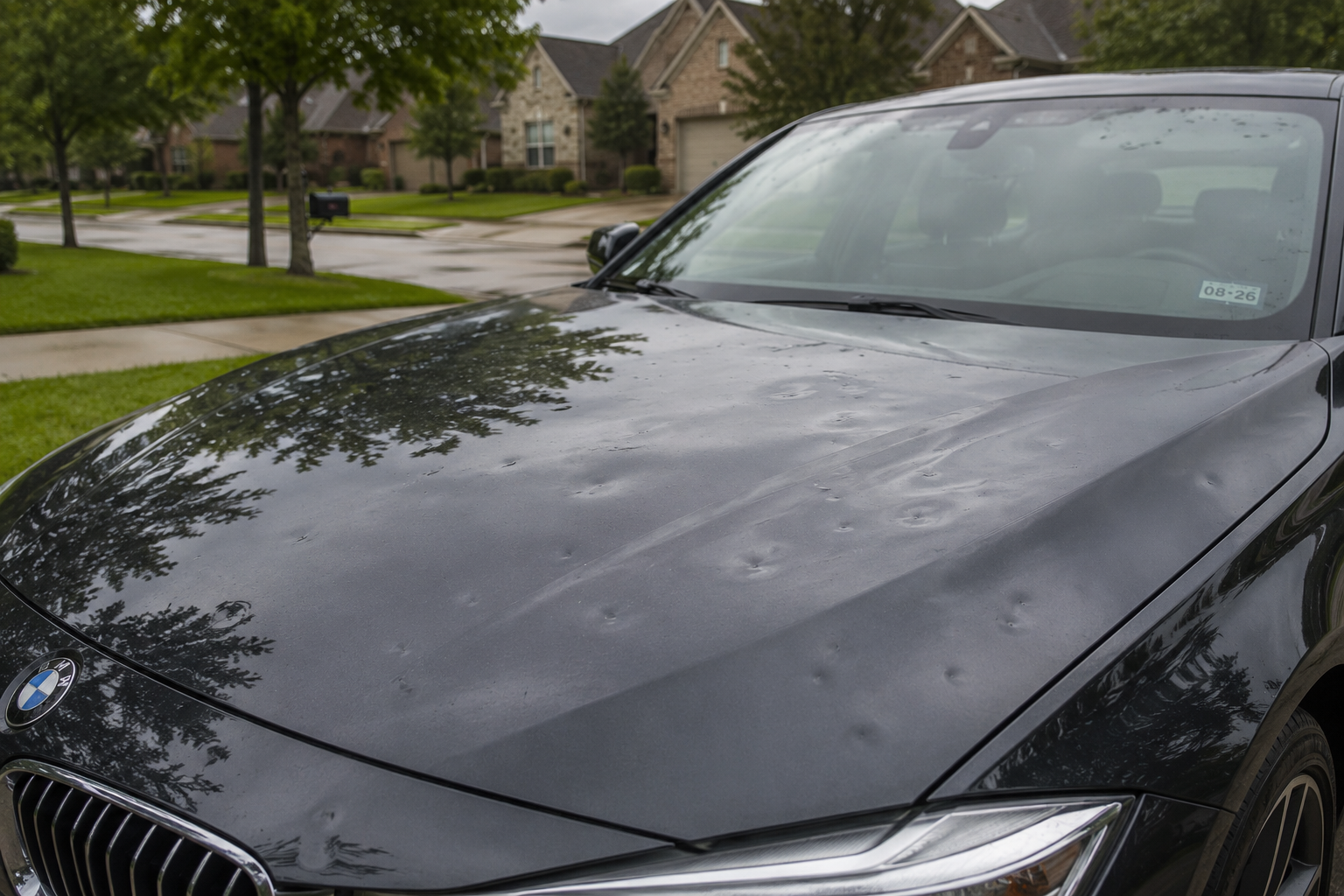 Technician from What The Hail Auto Dent Repair performing paintless dent repair on a hail-damaged vehicle in Downers Grove, IL.